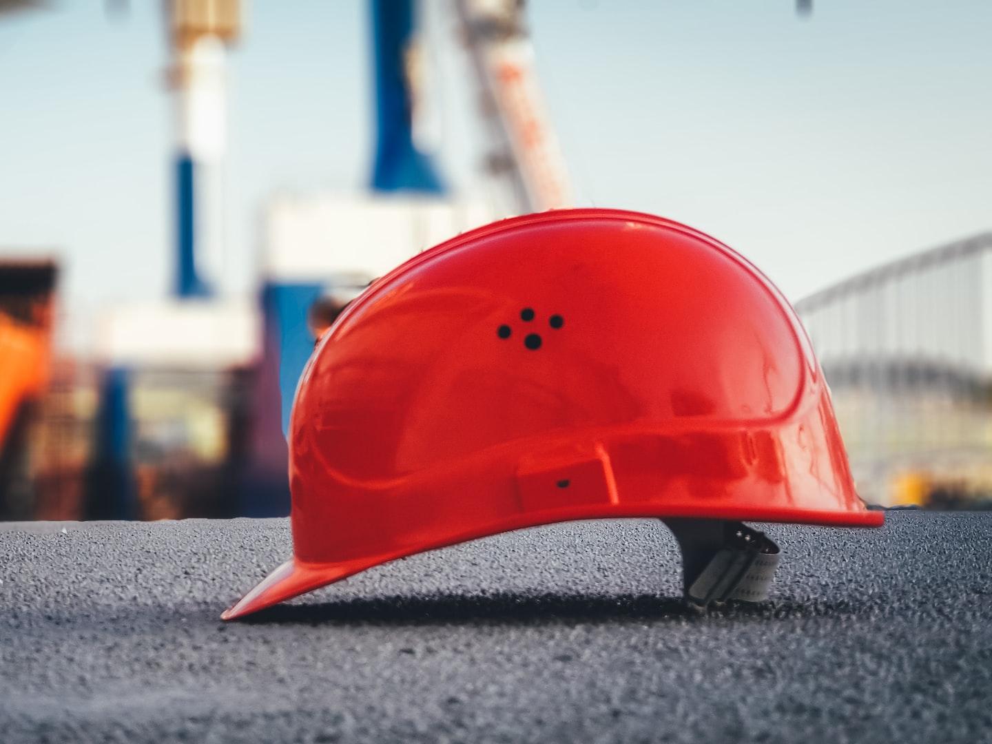 red hard hat on pavement\