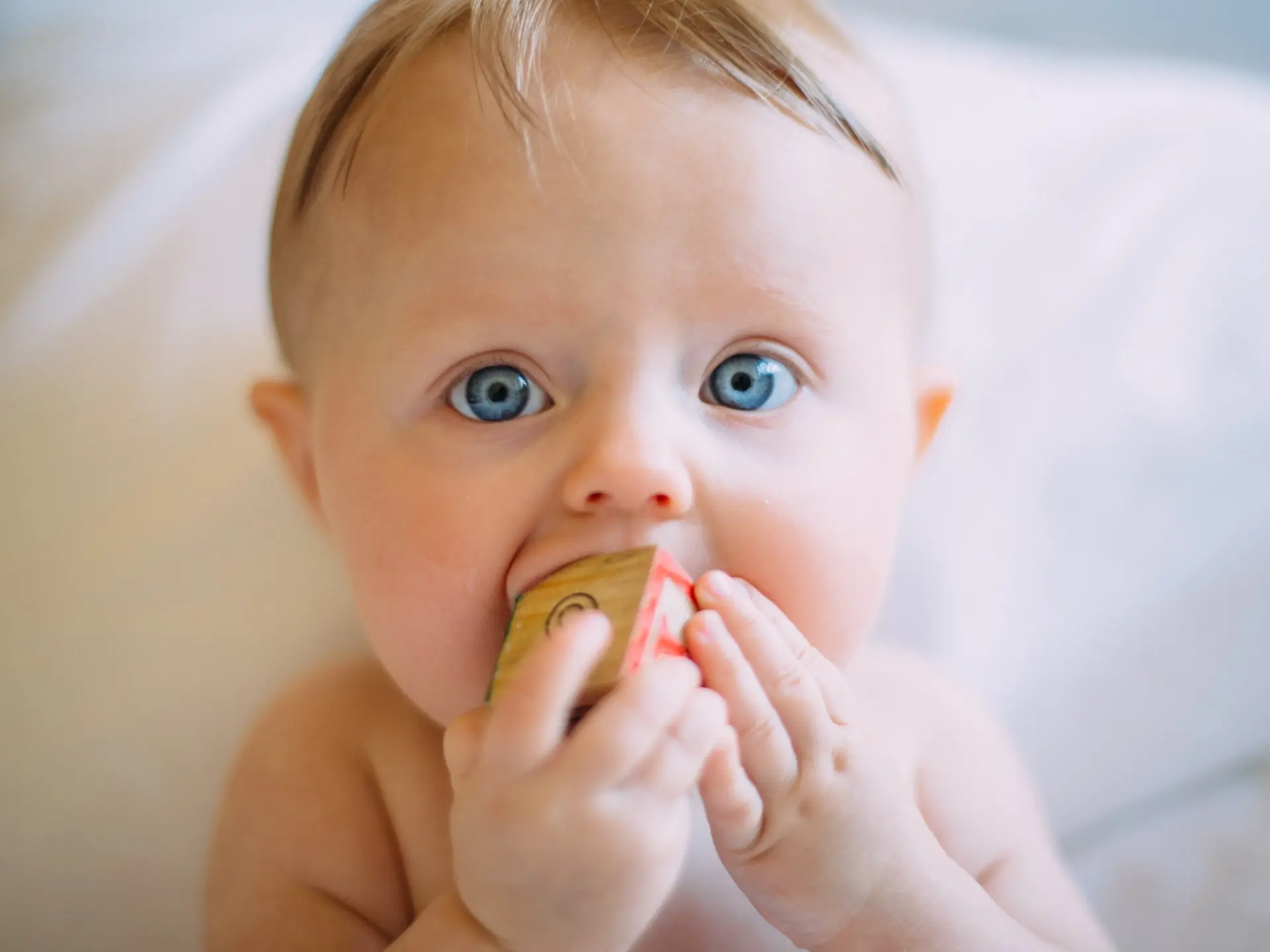 child with toy in its mouth